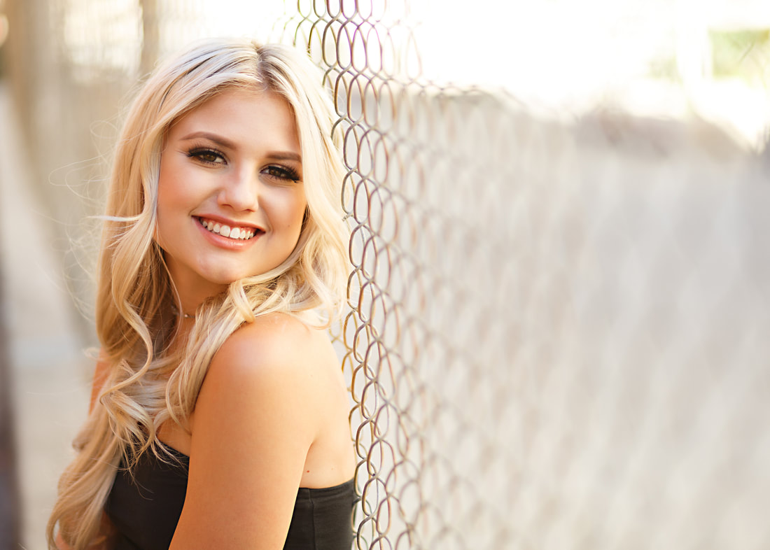 When blurred out, chainlink makes for a lovely element in senior pictures, like this one in an alleyway in Livermore