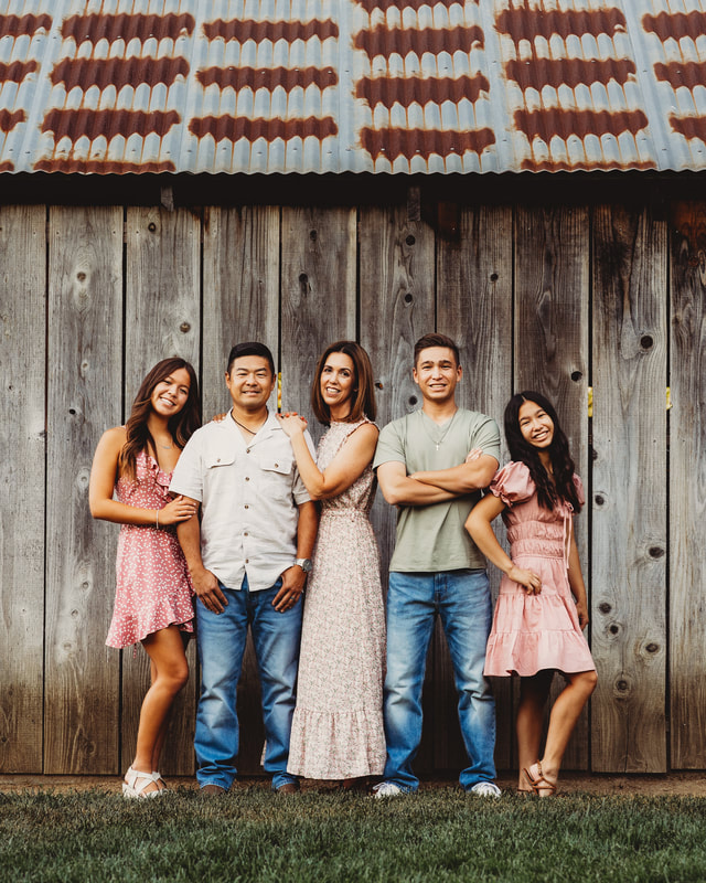 A family with three teenagers hangs out by a rustic barn in Livermore, CA.